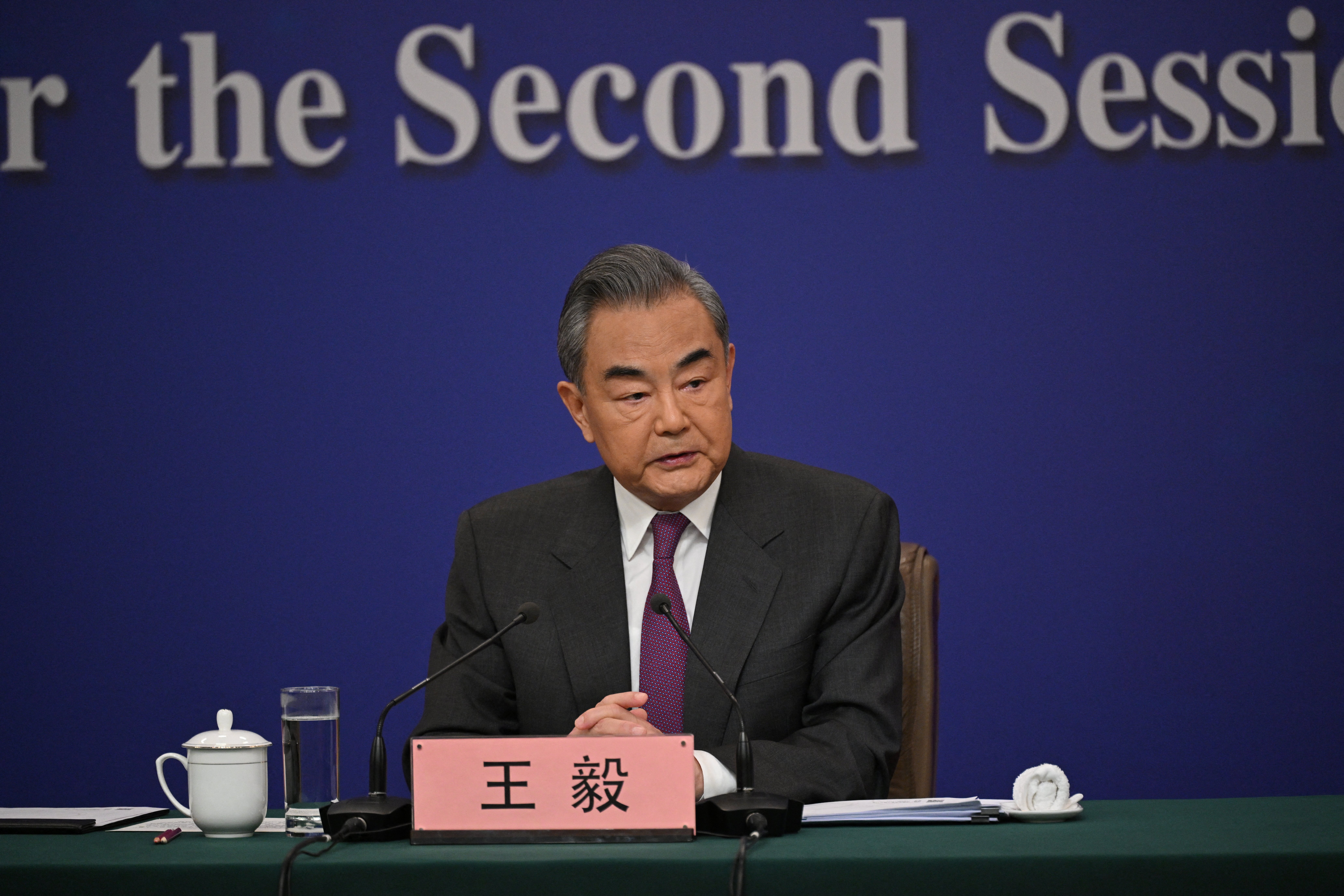 Wang Yi pada konferensi pers di Beijing. Ia duduk di meja.