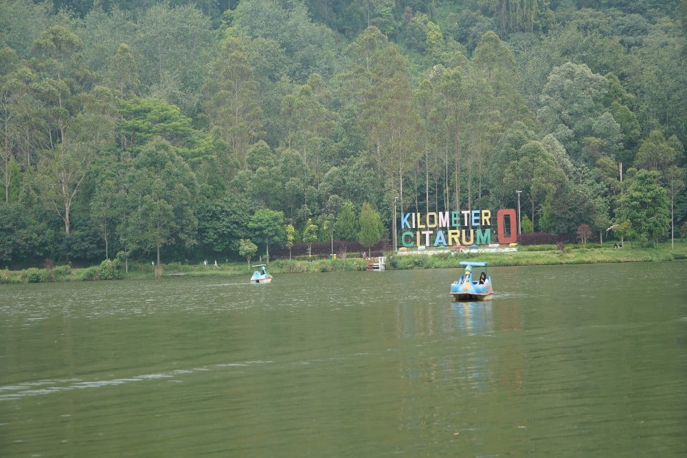 Wisatawan menikmati wahana perahu bebek saat berkeliling di kawasan Situ Cisanti, Kilometer Nol Citarum, Kertasari, Kabupaten Bandung, Jawa Barat