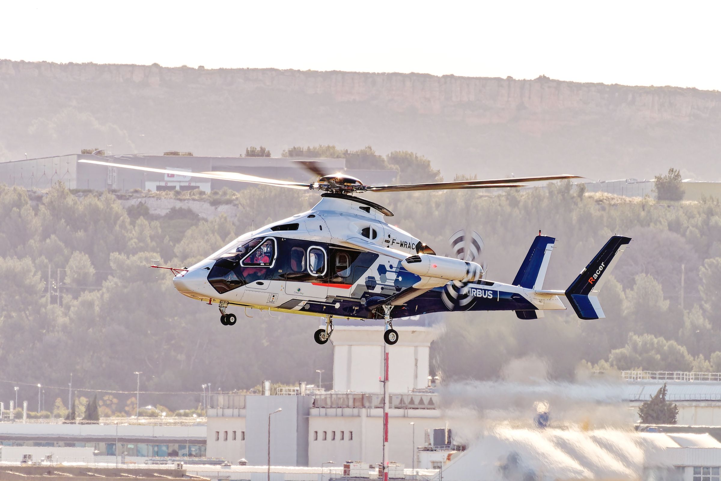 Helikopter biru putih dengan sayap dan rotor yang menghadap ke depan