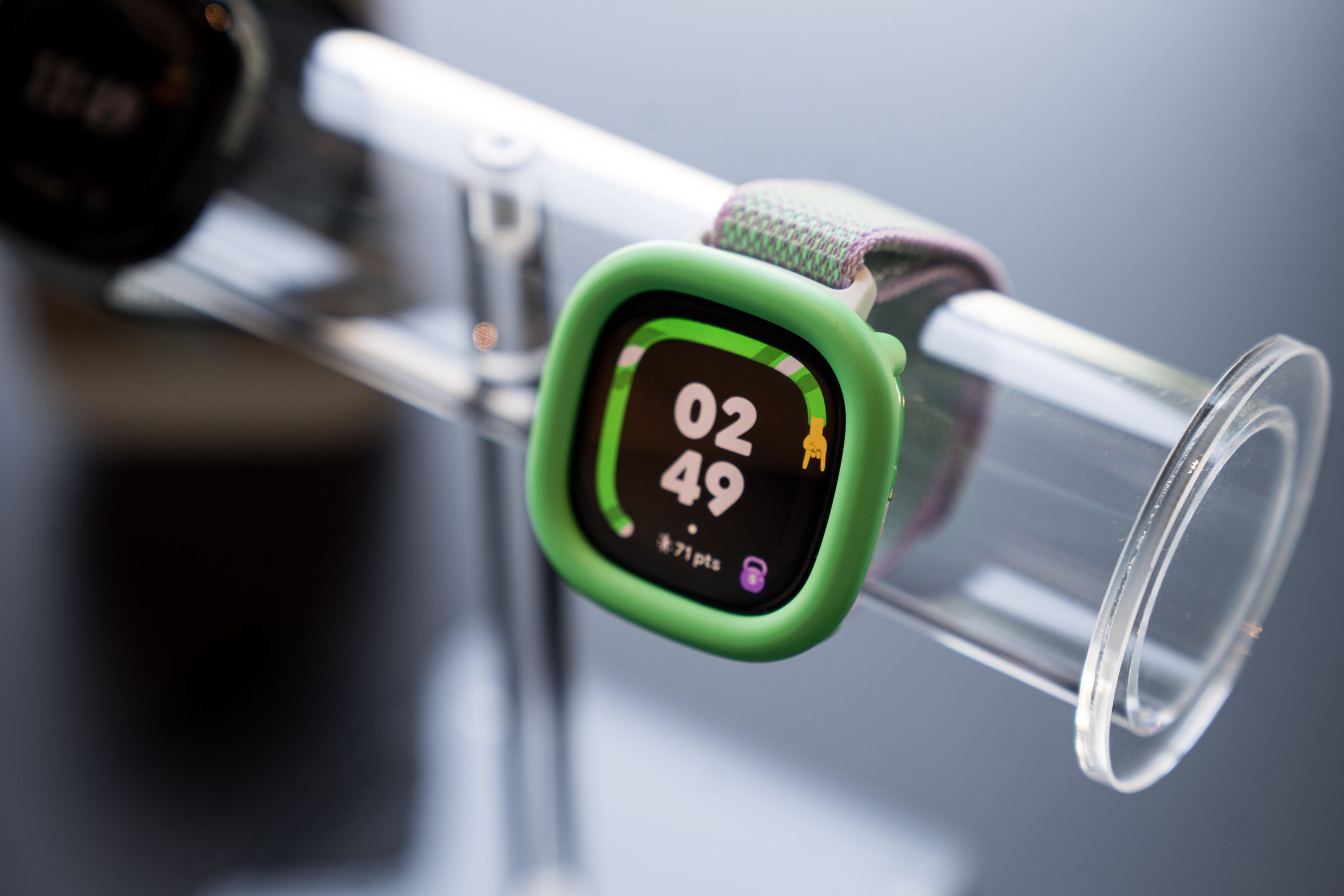 Tampilan dekat Fitbit Ace LTE varian Spicy Pebble dengan bumper hijau neon.