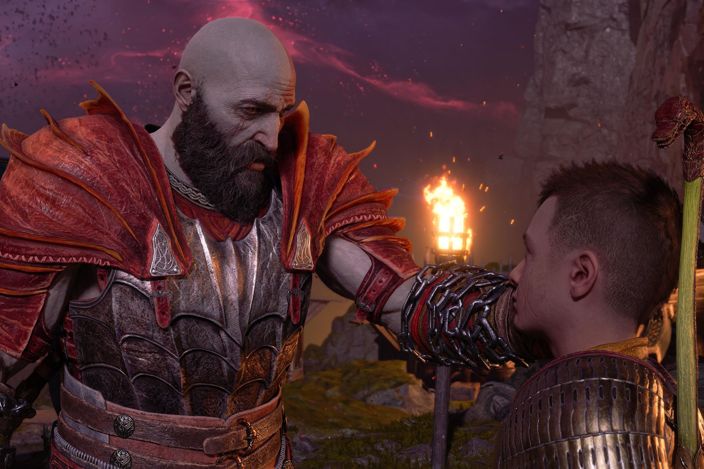 Cuplikan layar dari God of War Ragnarök yang menampilkan Kratos dengan lembut menyentuh wajah Atreus, putranya, untuk menghiburnya.