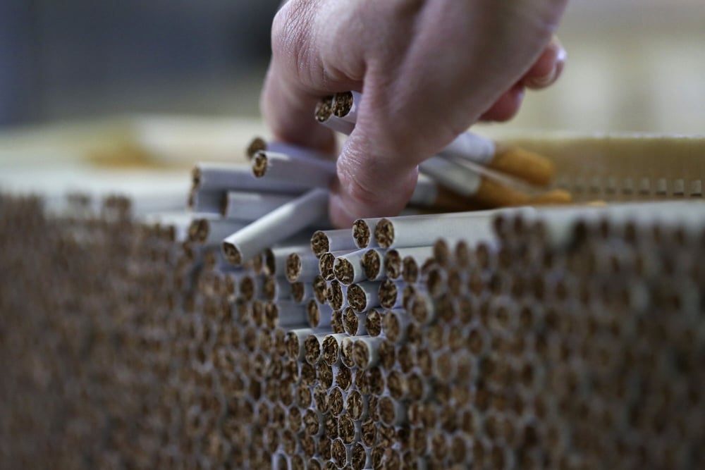 Para pekerja memeriksa rokok yang diproduksi di sebuah pabrik di Inggris. 